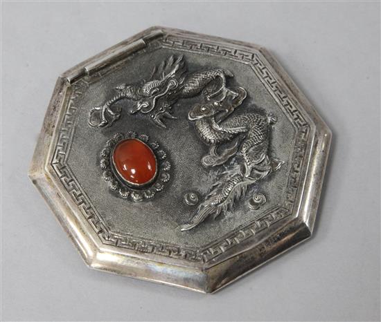 A Chinese white metal and chalcedony cabochon set octagonal compact, decorated with a dragon, 8cm.